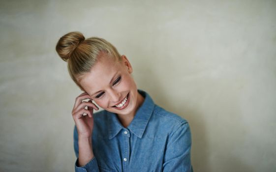 Smiling shyly. A beautiful young woman in casualwear - studio shot.