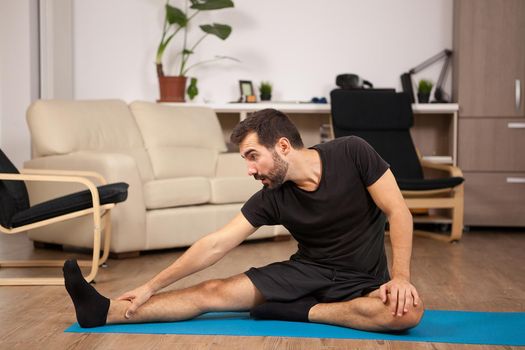 Young man practicing yoga in his living room