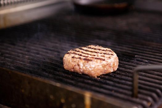 Chef is grilling a meat burger on the grill