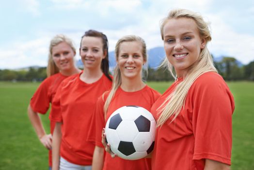 Shell lead the team to victory. Portrait of a young female soccer player and her teammates.