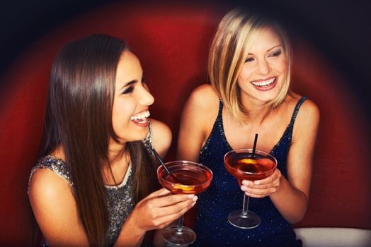 Catching up over drinks. Two young women enjoying cocktails in a nightclub.