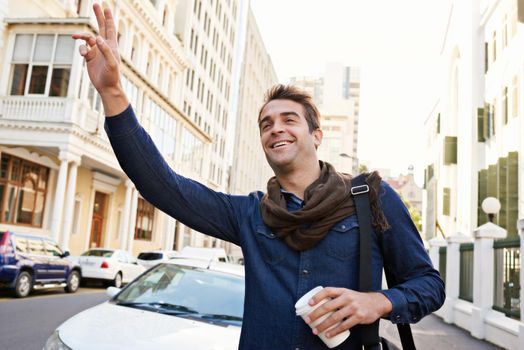 Hes in a great mood this morning. a handsome man hailing a cab in the city.
