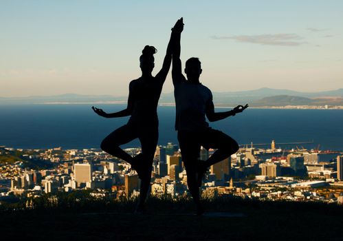 Couple, silhouette and yoga in spiritual fitness and wellbeing against a city background. Dark shadow of people in meditation exercise balance together in healthy mind, body and spirit in calm nature