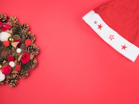 Beautiful Christmas wreath with santa hat on red background
