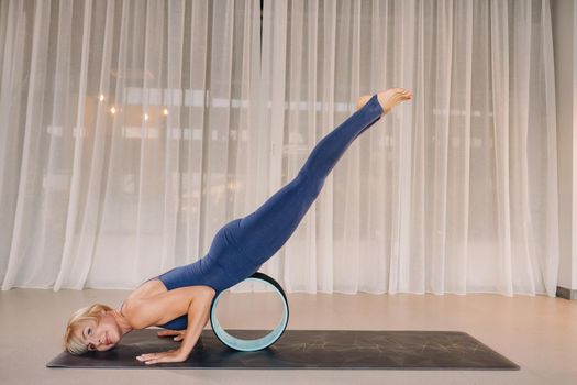 A woman does yoga with a Pilates ring, stretching the body, meditating training softness