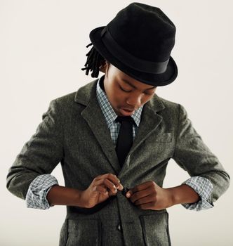 Youre never too young to look smart. A young African-American boy dressed up in a jacket with a tie and a hat.
