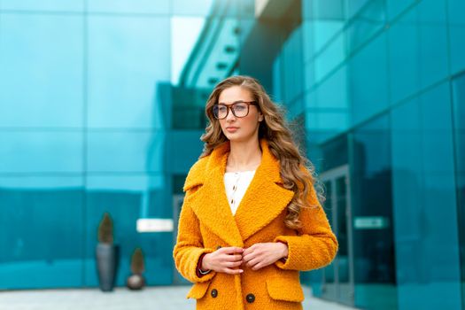 Business woman dressed yellow coat standing outdoors corporative building background