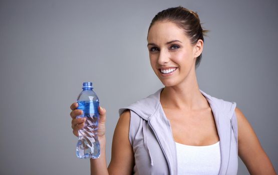 Hydration is important. Portrait of an attractive young woman holding a bottle of water.