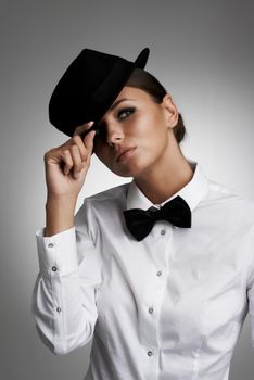 Well, hello there. A young woman in a shirt and bow tie tipping her hat to you.