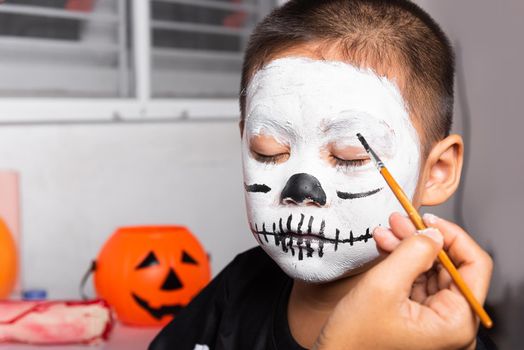 Asian mother and kid son getting makeup halloween face painting look like ghost