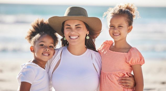 Family, children and beach with a girl, mother and sister together by the ocean for bonding during summer. Nature, sea and love with a daughter, sibling and parent on vacation or holiday by the water