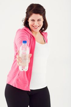 Heres some H2O. Studio shot of a young woman in sportswear offering a bottle of water to the camera.