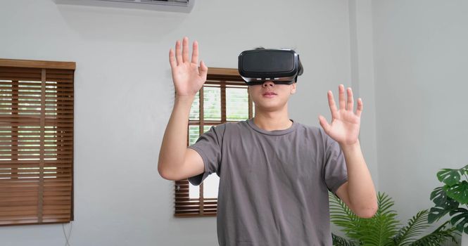 young asian man touching the air during the VR experience