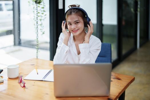 woman using a computer and earphone during a video conference