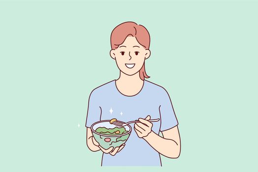 Smiling woman eating healthy vegetable salad