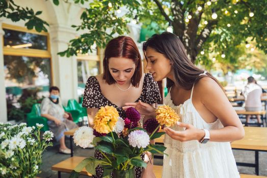 Two young women make up a beautiful festive bouquet.