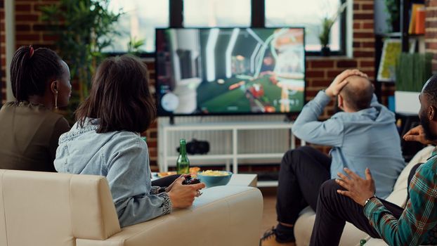 Diverse people playing video games to have fun at home