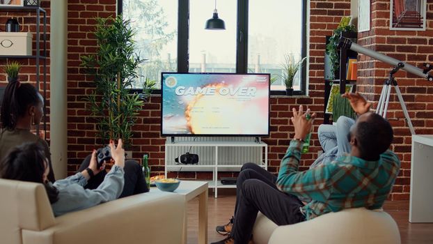 Angry friends losing video games competition on tv console