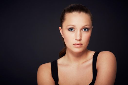 Natural and candid beauty. Cropped portrait of an attractive brunette against a black background.