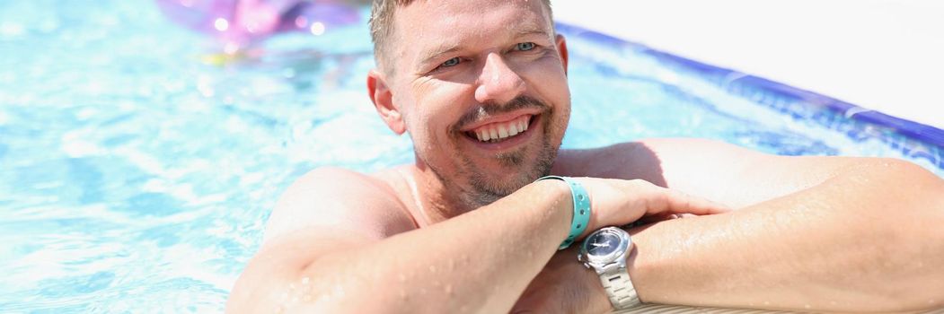Middle aged man chill in swimming pool on summer holiday