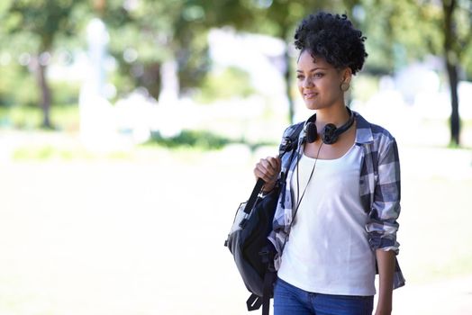 Cool and casual on campus. A young woman with headphones around her neck.
