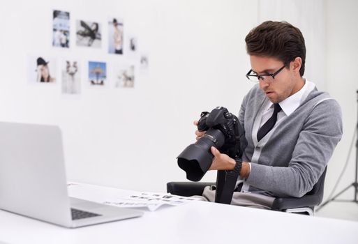 Scrutinizing every image. a young photographer sitting at his desk editing images.