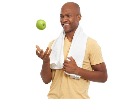 Hes handsome and healthy. a handsome African-American man tossing an apple up in the air.