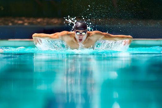Perfect butterfly stroke. a male swimmer doing the butterfly stroke toward the camera.