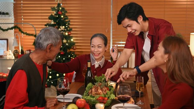 Happy family enjoying in Christmas meal in dining room. Christmas, New year, thanksgiving and celebration concept
