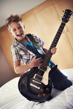 Youre never too young to learn a Slayer riff. A little boy playing an electric guitar in his bedroom.