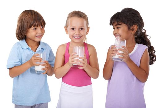 Getting all the calcium they need. A group of thee children holding glasses of milk.