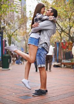These are happy days. Full length shot of a young couple hugging in a downtown street.