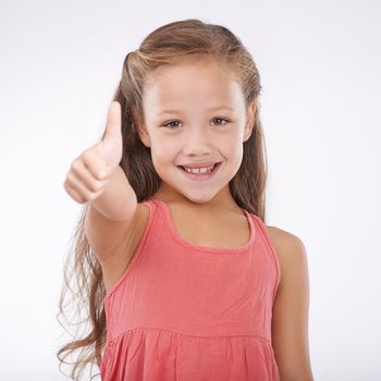 Shes so happy and carefree. Studio portrait of a cute young girl giving a thumbs-up to the camera.