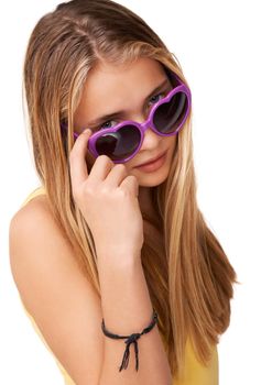 Peering over at you. Portrait of a cute teen girl peering over her heart-shaped glasses.