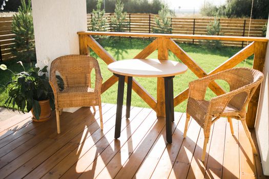 Cozy wooden terrace of country house or cottage with garden view - table and chair for relaxing evening