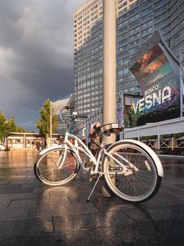 MOSCOW, RUSSIA - September 17, 2022. White bicycle parked on Novy Arbat. Wet pavement of famous street after rain.