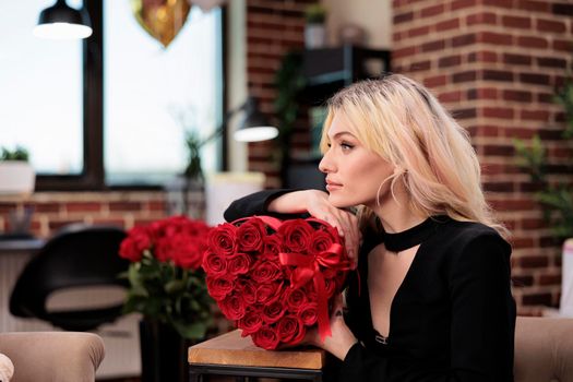 Beautiful thoughtful woman holding roses, side view