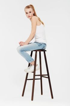 Simplicity is perfection. Portrait of a beautiful young woman on a chair isolated on white.