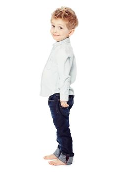 Look how tall Im getting. Side view of a cute little boy standing against a white background - portrait.