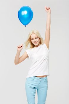 Feeling the excitement. A young woman holding a balloon against a white background.