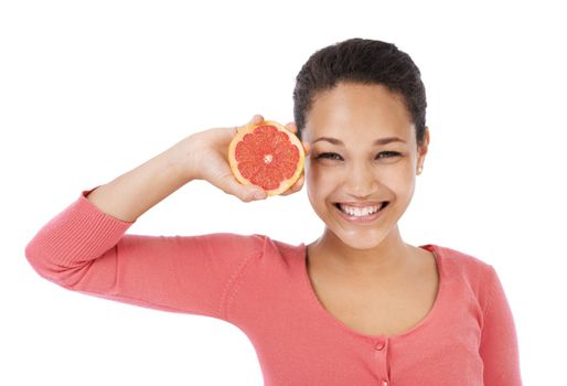 Its rich in anti-oxidants. Young woman smiling while holding up a grapefruit - isolated on white.