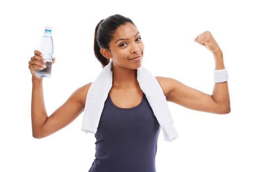 Her fitness regime is a success. A young woman holding a bottle of water and flexing her biceps after an energizing workout.
