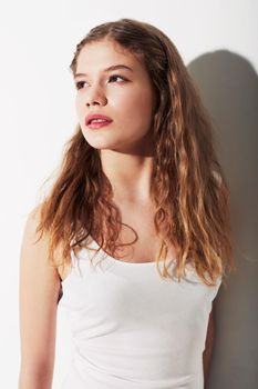 Casual and beautiful. A beautiful young teenage girl standing against a white background.