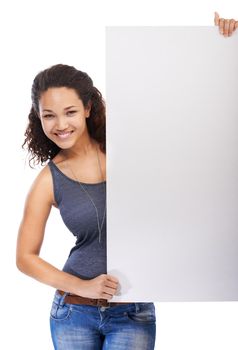 Displaying your advert. Portait of a beautiful young woman holding a placard and smiling against a white background.