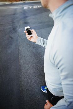 On the go and always connected. A jogger looking down at his smartphone.