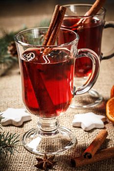 Glass of Christmas mulled wine with spices, orange and cookies on sackcloth