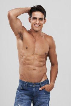 In control of his physique. A handsome young man smiling at the camera.