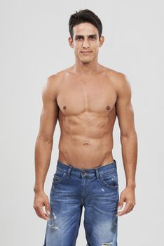 Unashamed of being himself. A handsome young shirtless man posing in studio.