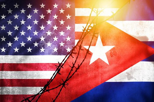Grunge flags of USA and Cuba divided by barb wire sun haze illustration