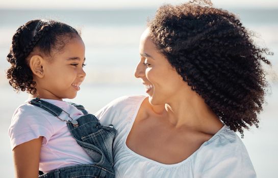 Mom with child at beach smile, make eye contact and black family happiness. Black woman with girl, happy spend time as mother and daughter, on family holiday or vacation by the ocean in Brazil